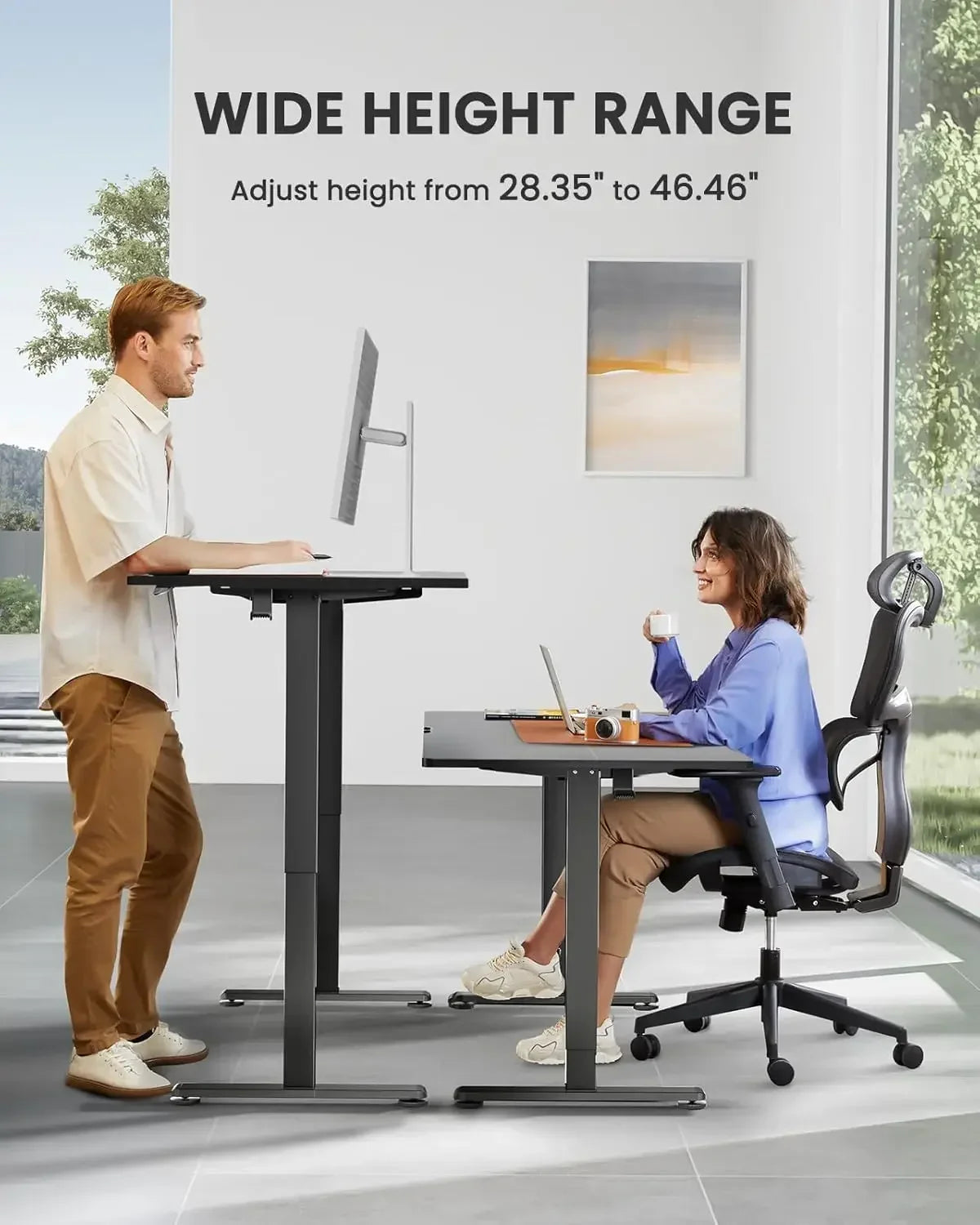 Two people using a height-adjustable desk in an office setting.